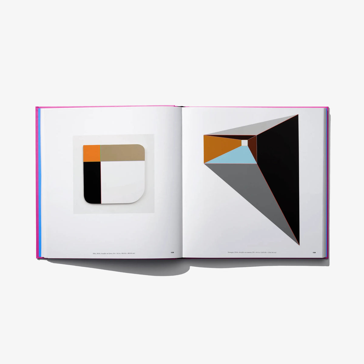 Art book open spread with geometric black, gray, and orange abstract designs