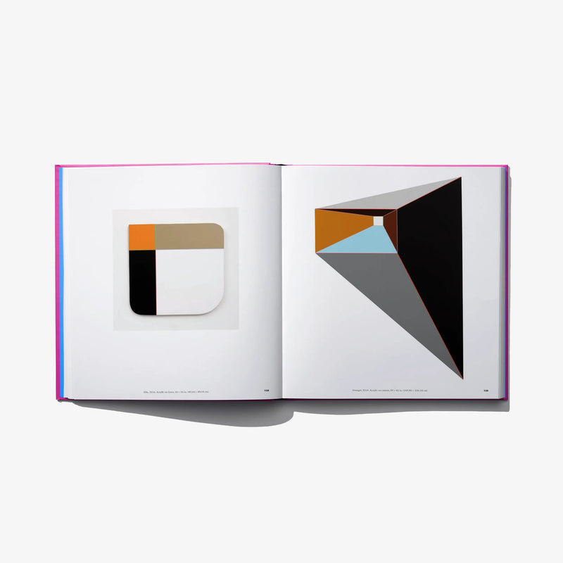 Art book open spread with geometric black, gray, and orange abstract designs