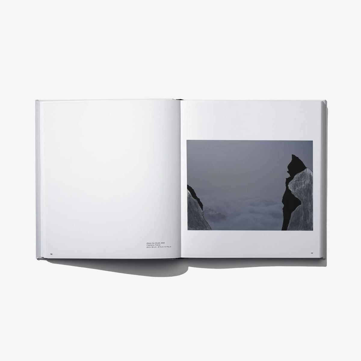 Open photo book with dark mountain print on right page and blank left page