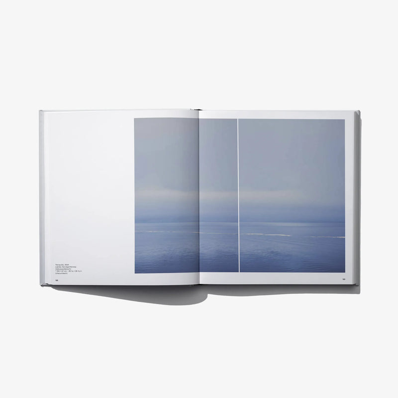 Open photo book with large blue ocean print across two panels on the right spread