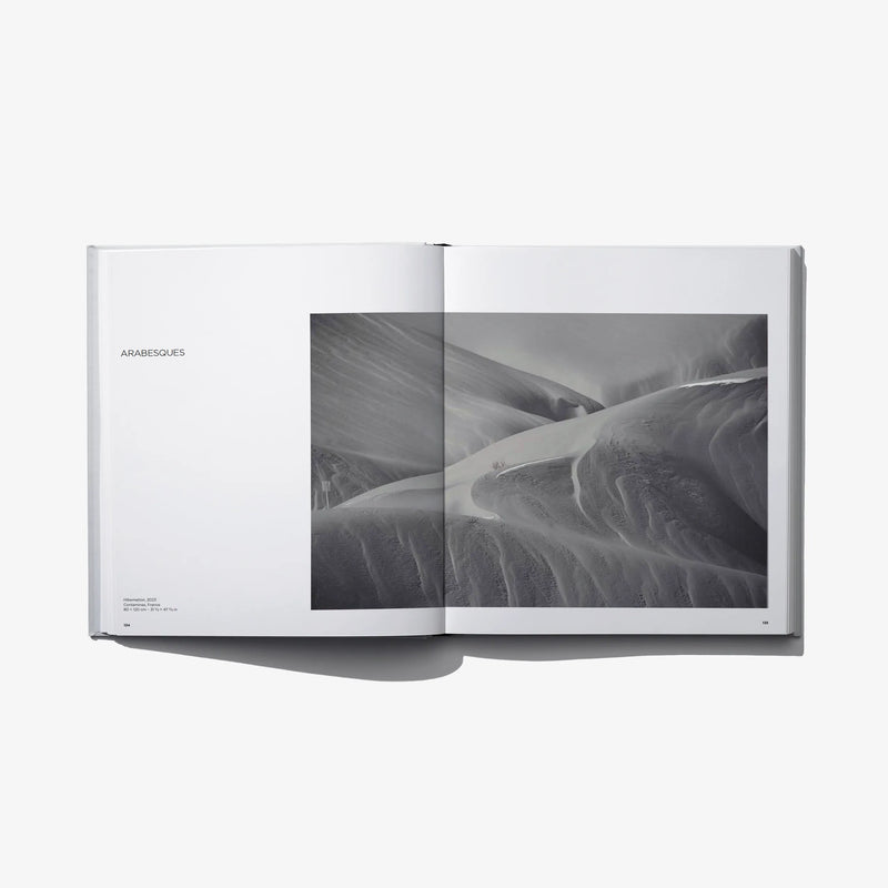Open photo book with black-and-white sand dunes print across the right spread