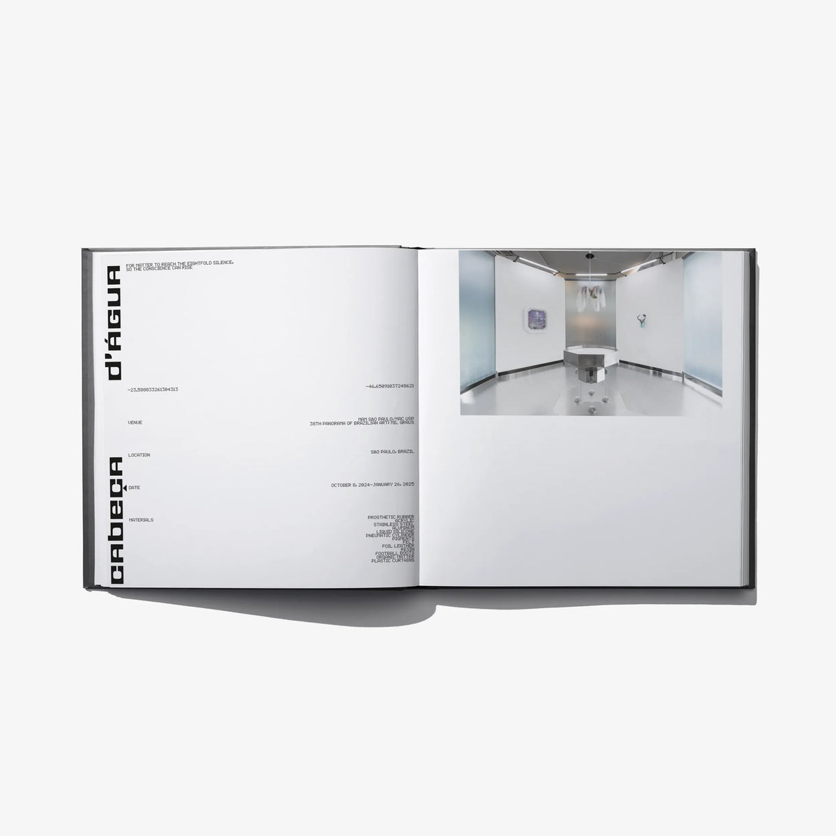 Open hardcover book with minimalist layout and a gallery interior photo