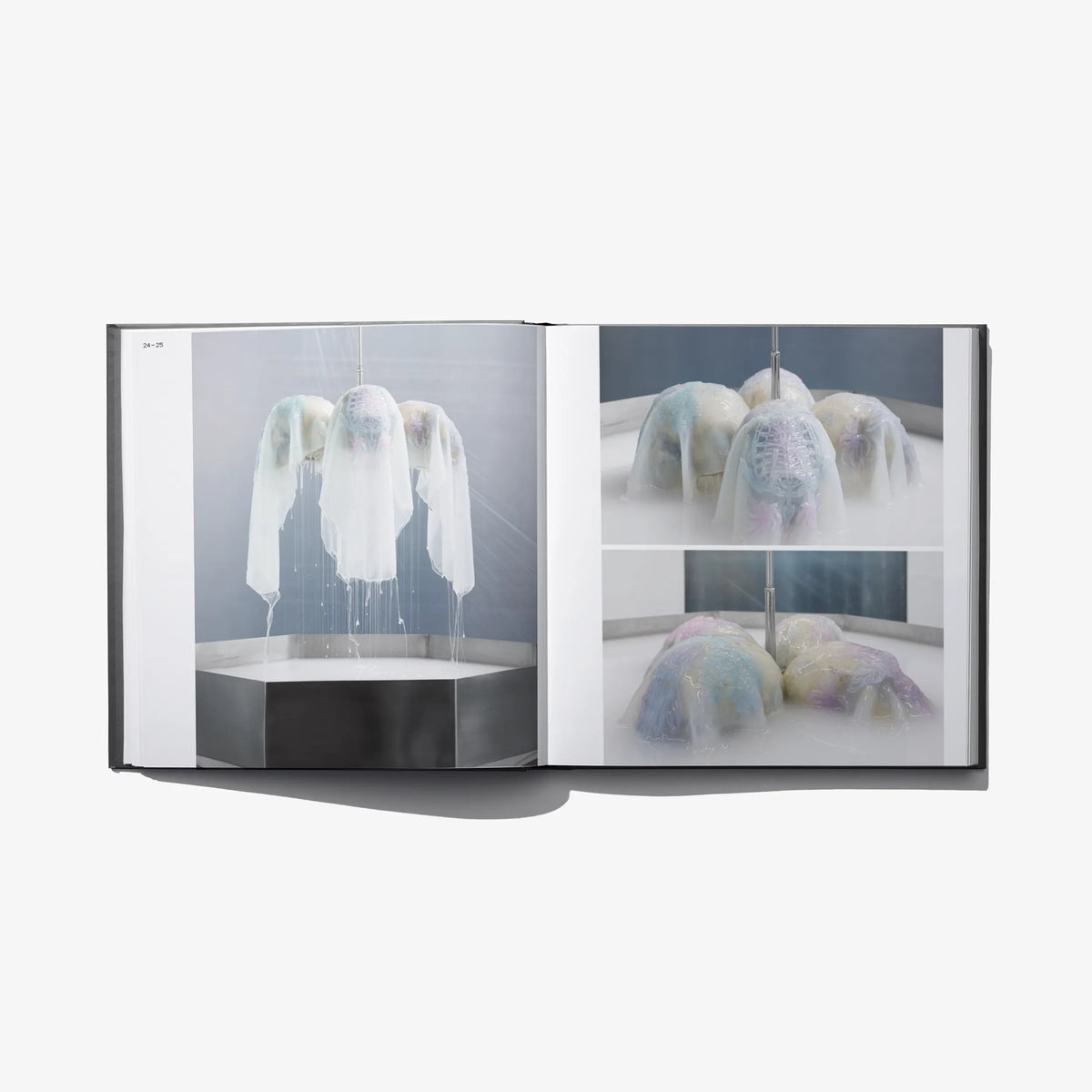 Open hardcover book with chandelier-like hanging translucent textile pieces