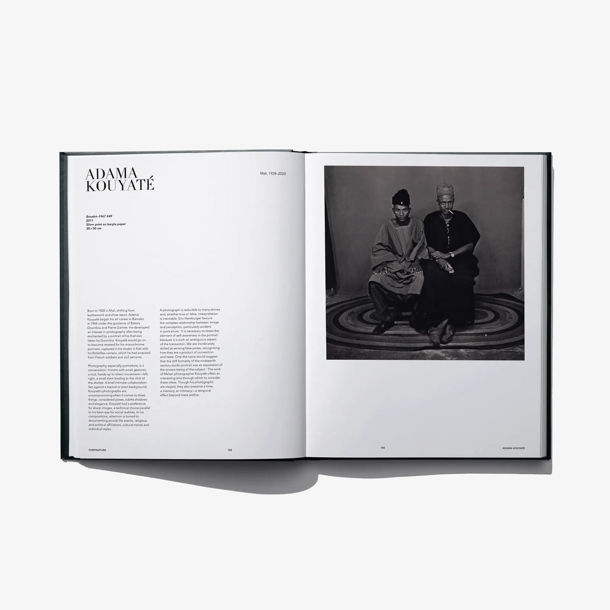 Open art book spread with black-and-white photo of seated figures on the right
