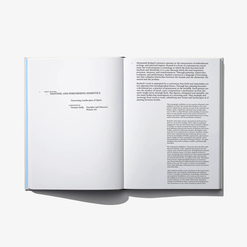 Open hardcover art book spread with paragraphs and blocks of text