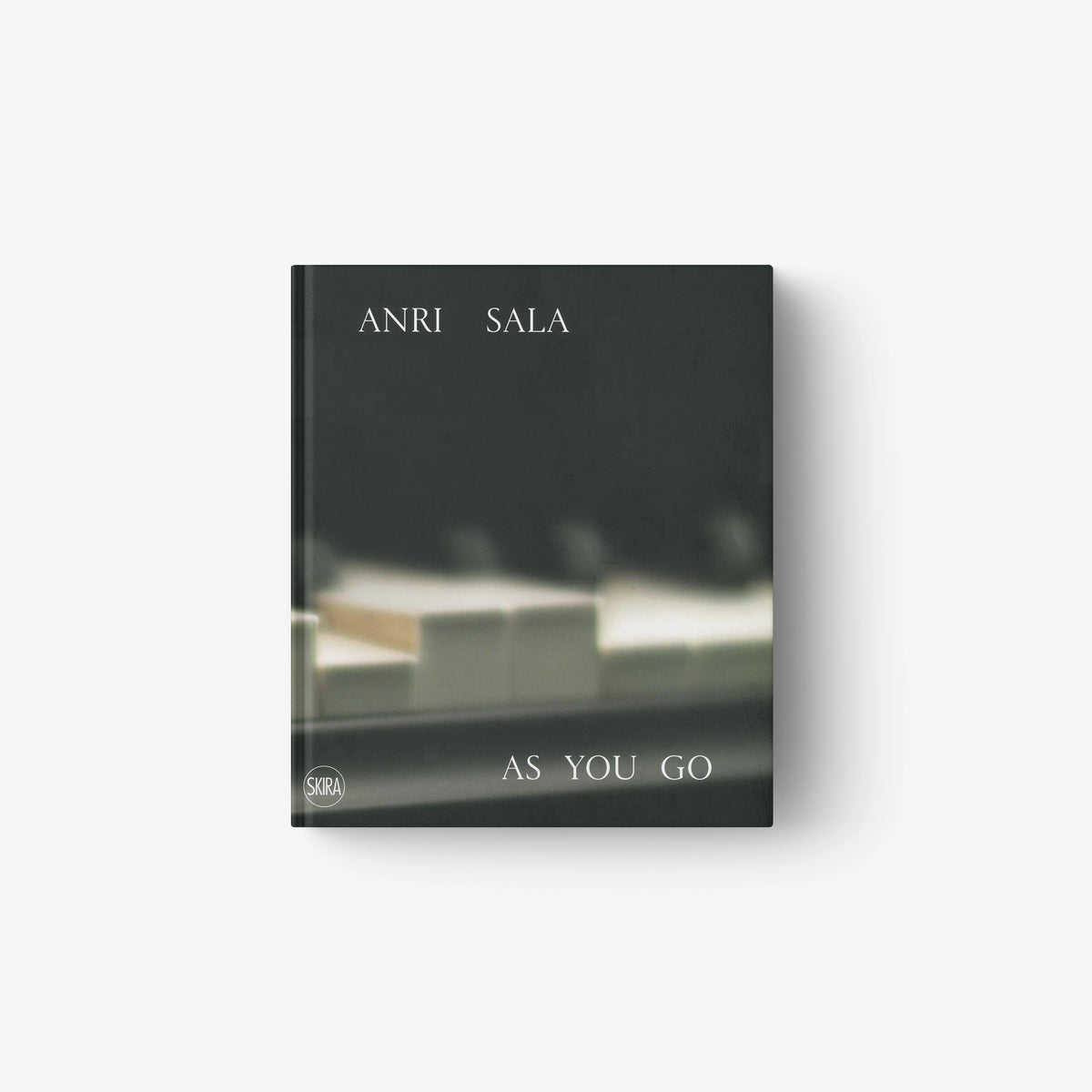 Dark-toned book cover featuring blurred piano keys with white text "ANRI SALA" and "AS YOU GO".