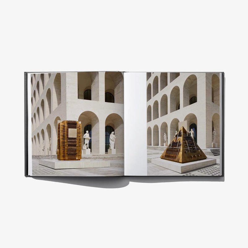 Open hardcover book with architectural exhibit photos across two pages
