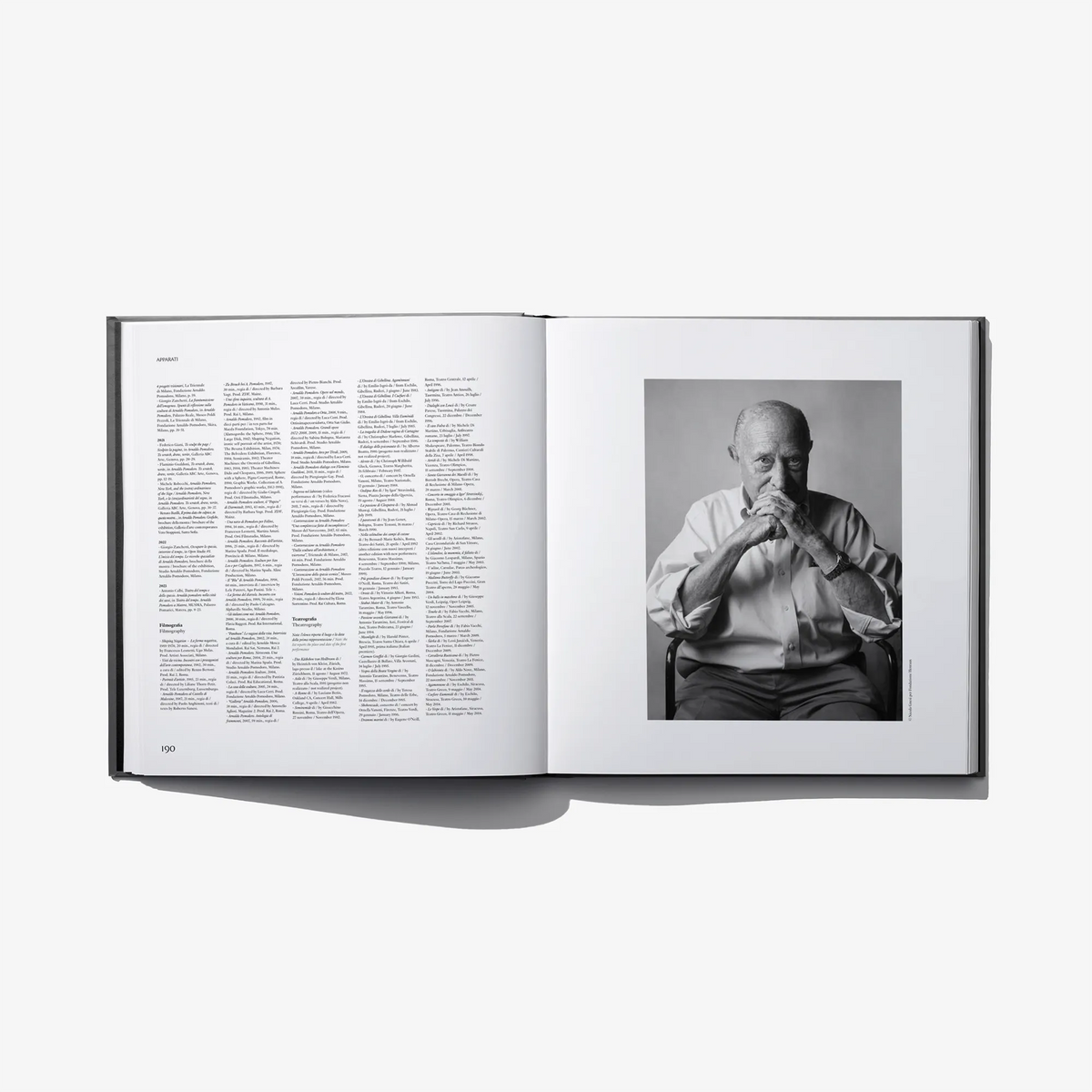 Open hardcover book with page text and black-and-white seated portrait photo