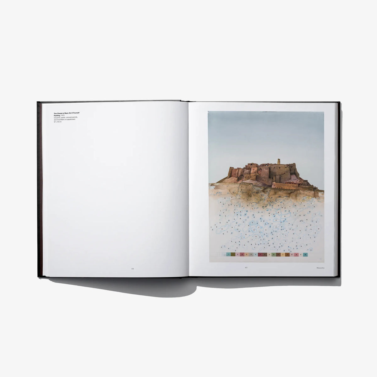 Open art book spread with blank left page and desert artwork with color blocks