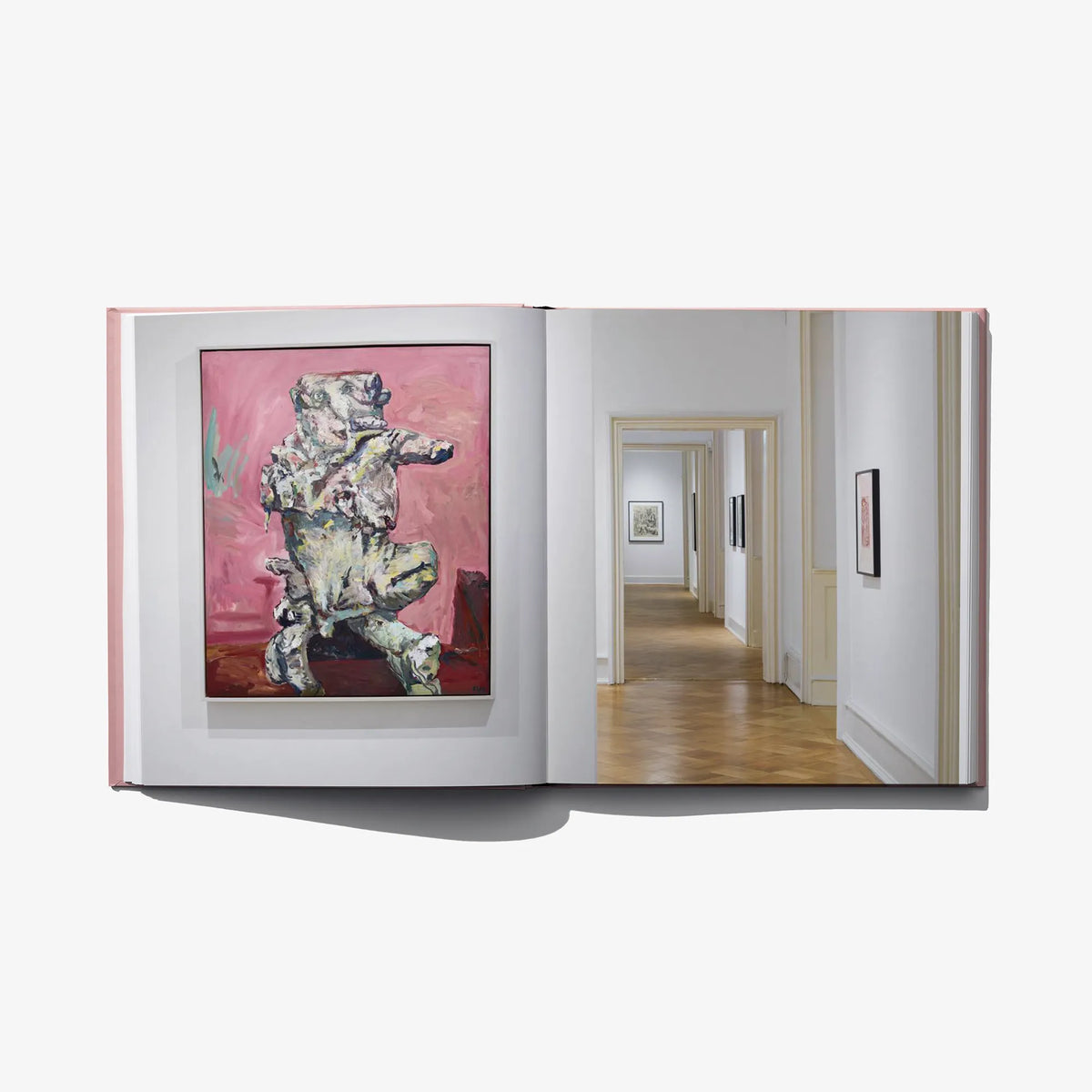 Open art book spread with framed artworks and gallery hallway photo