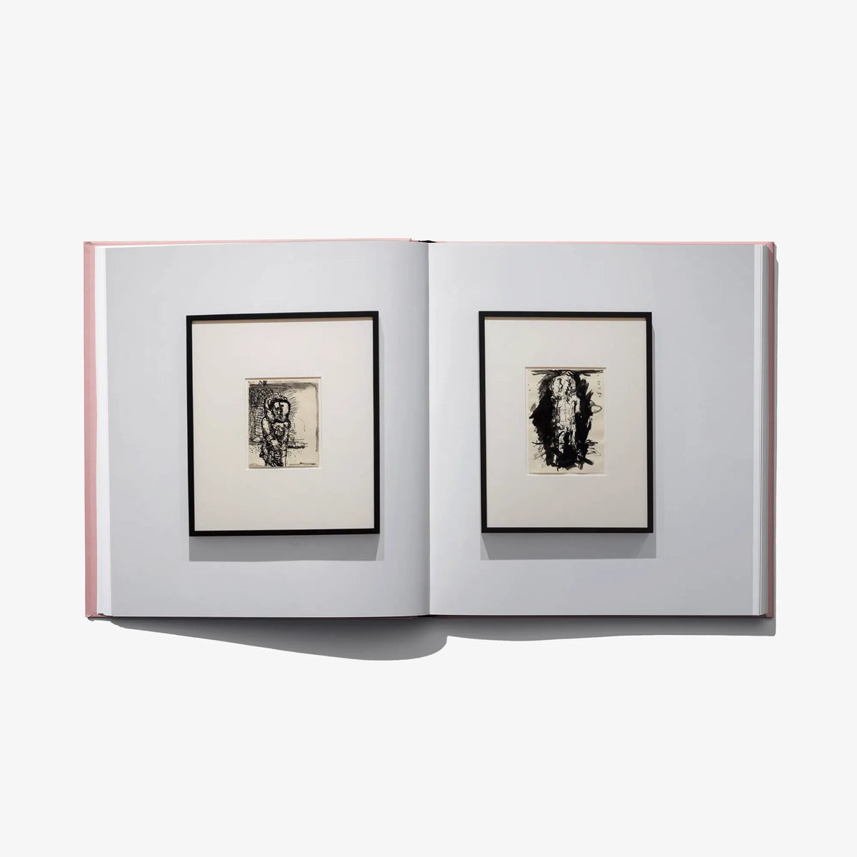 Open art book spread with two framed black-and-white prints