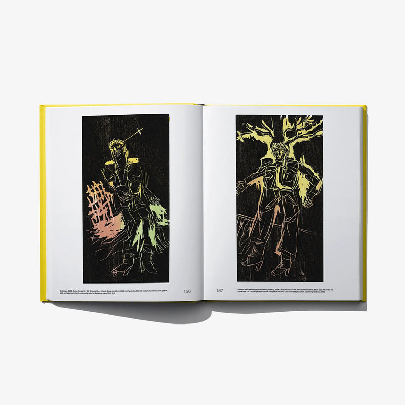 Opened art book showing two dark-backed prints with yellow line artwork