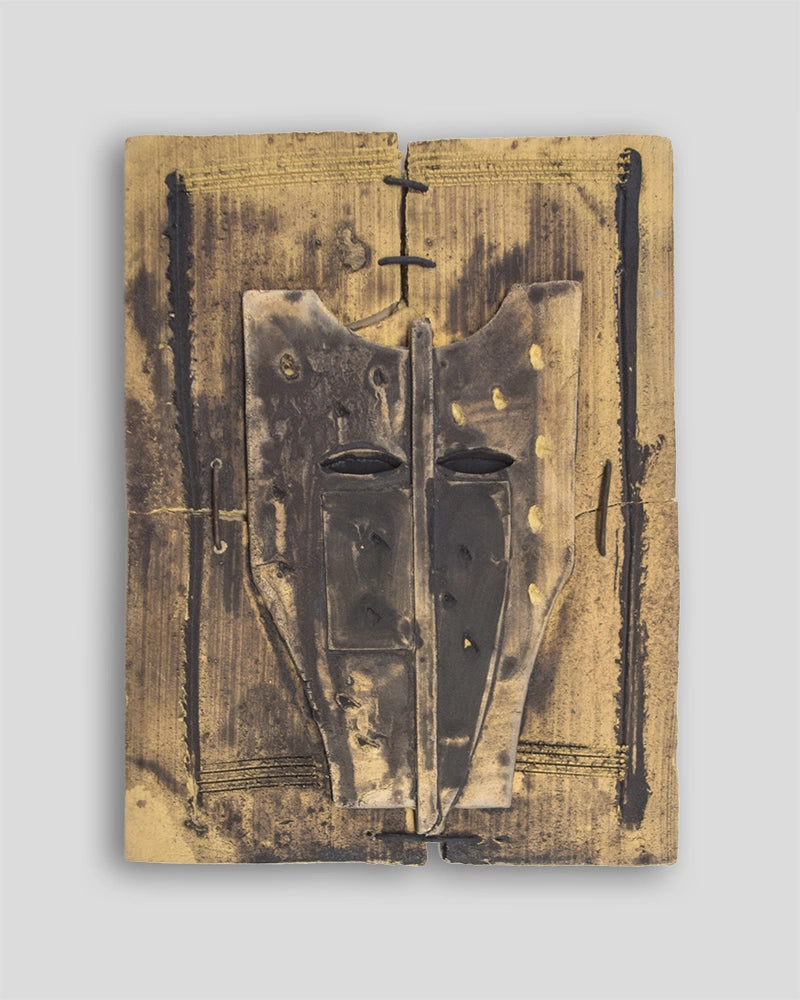 Limited edition wall sculpture by Skira Arte in terracotta dipinta, with painted yellow and dark facial mask design