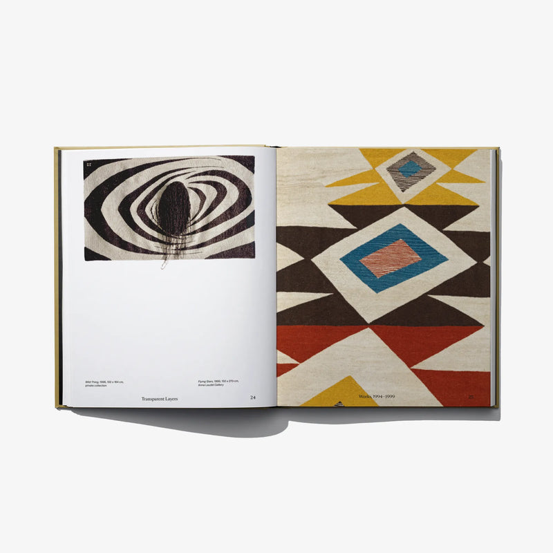 Open art book showing left black spiral print and right geometric diamond pattern