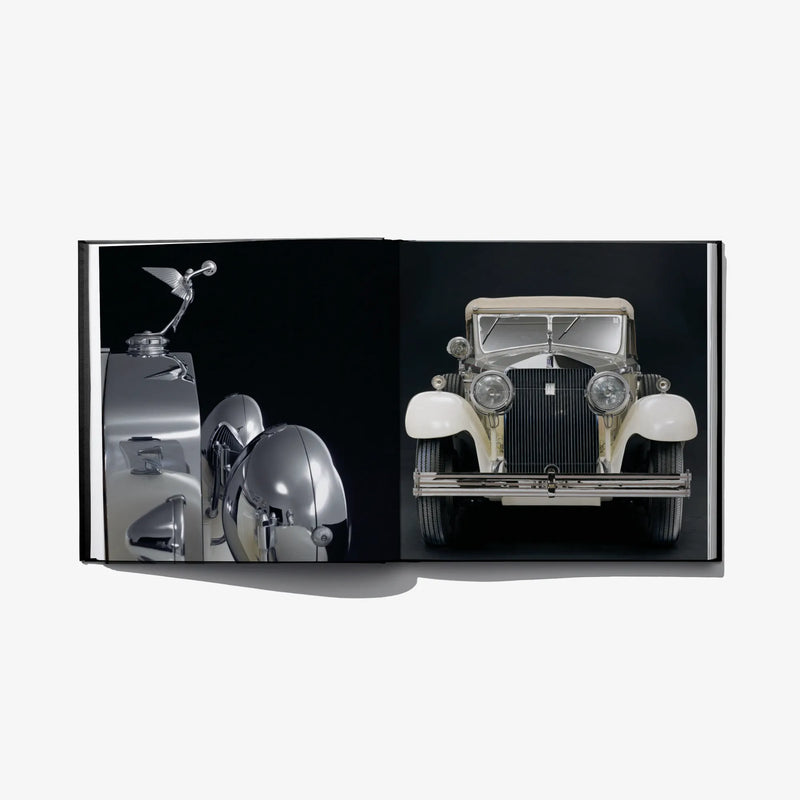 Open hardcover book spread with front view of a vintage silver car