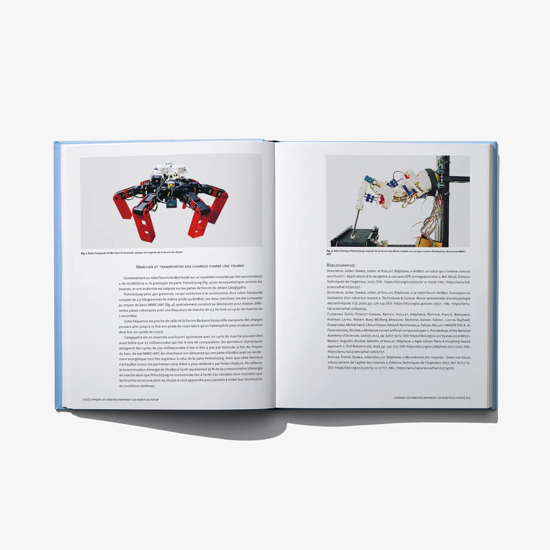 Open hardcover book with red-and-black robotic arm sketches and notes on right page