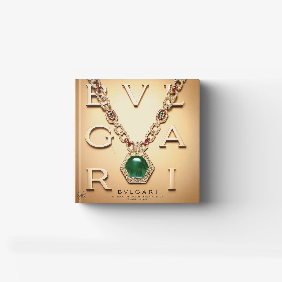 Illustrated jewelry history book in gold with Bulgari and serpent motif focus, Skira Arte, featuring a green gemstone pendant