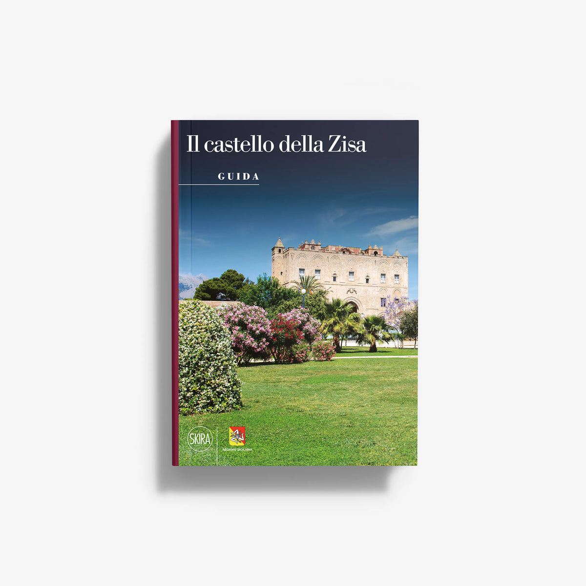 Travel guidebook with blue cover, castle scene, and garden flowers over a lawn