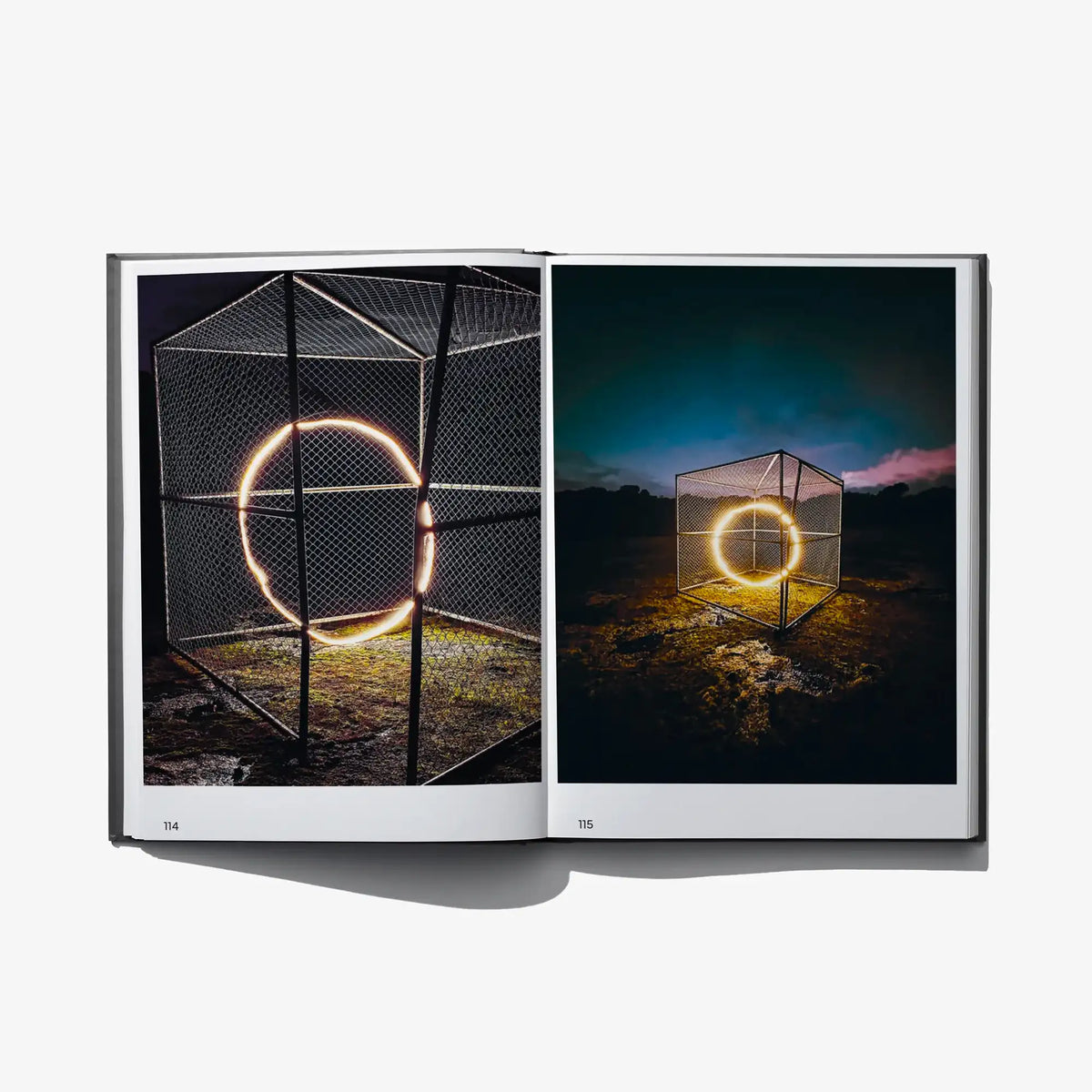 Open art book spread with glowing orange circle light effects over outdoor scenes