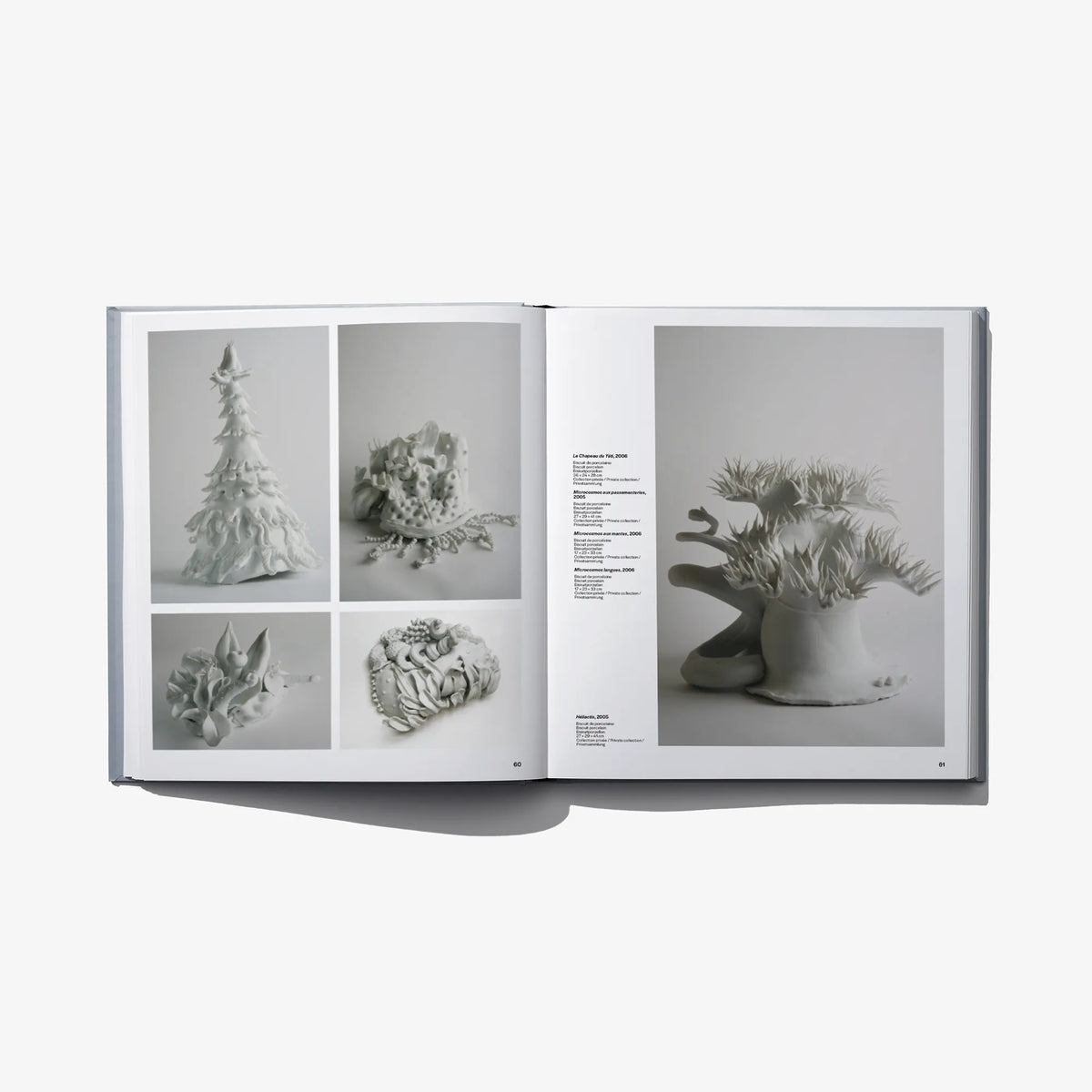 Open hardcover art book spread with framed sculpture photos on both pages