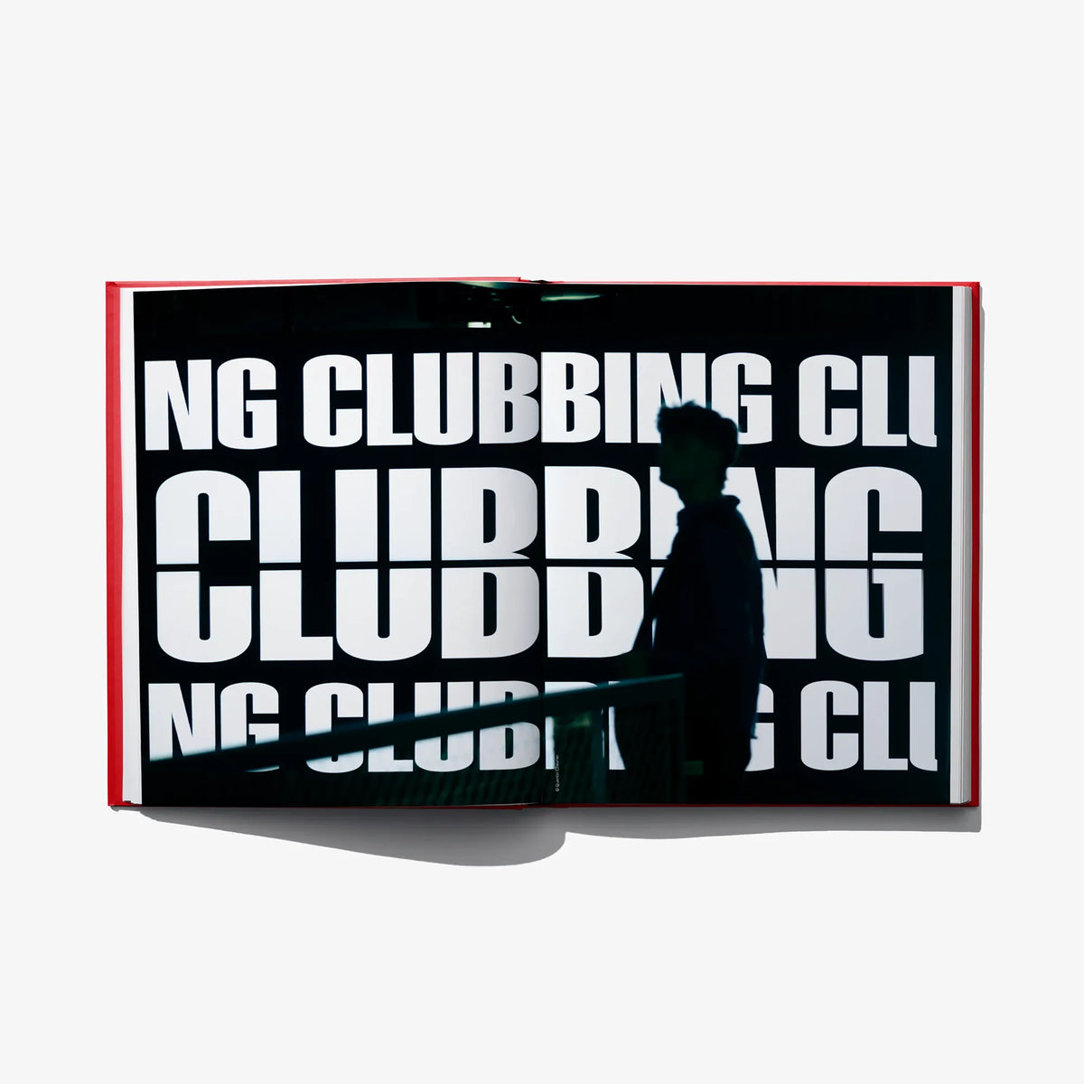 Open club culture book spread with bold white “CLUBBING” lettering on dark background