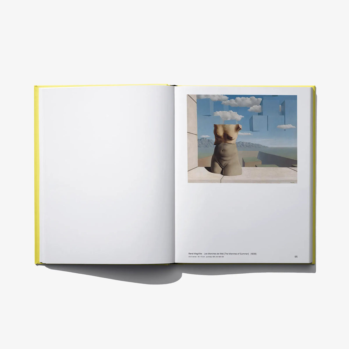 Open art book with blank left page and landscape photo panel on right