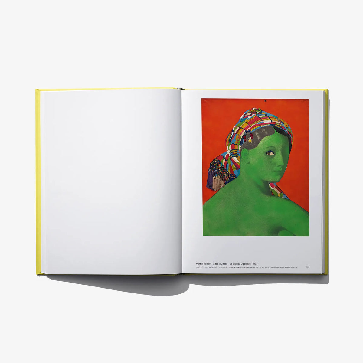 Open art book with blank left page and green face portrait print on right
