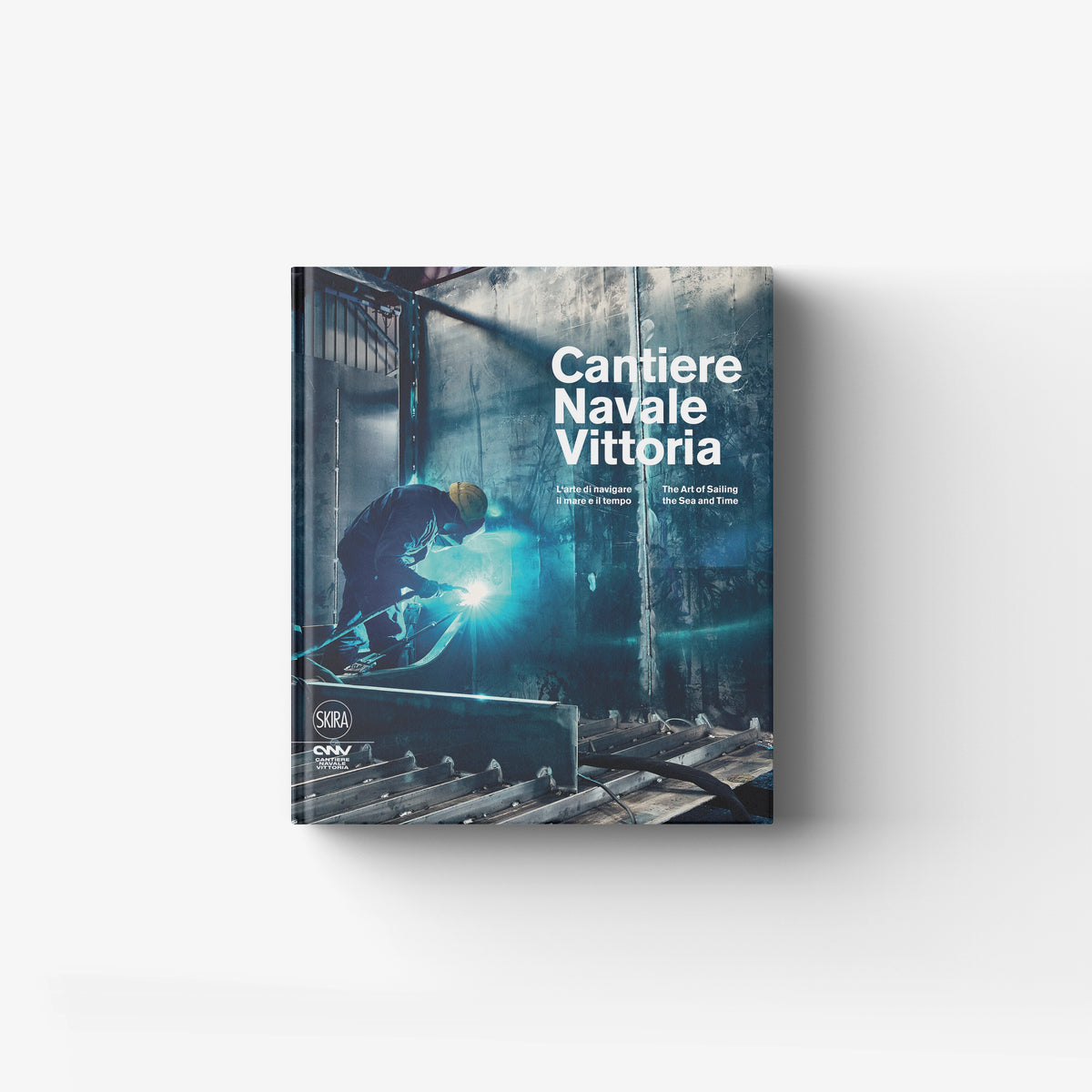 Hardback book in blue and teal with Skira Arte branding, featuring four generations of the Adria shipyard
