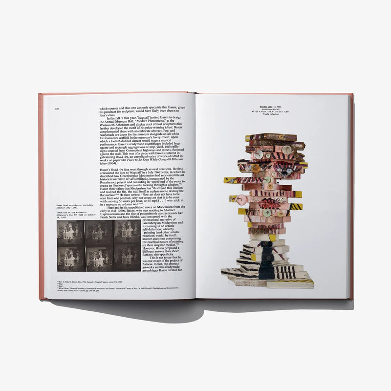 Open art book spread with paragraph text and a stacked sculptural artwork on right