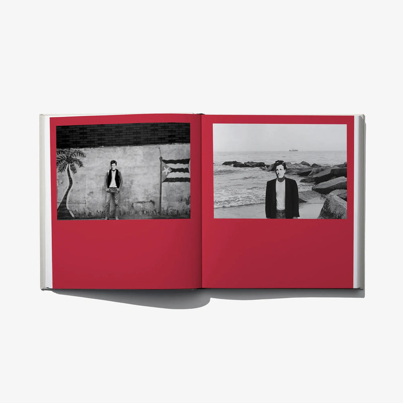 Open photo book spread with two black-and-white portrait photos on red page