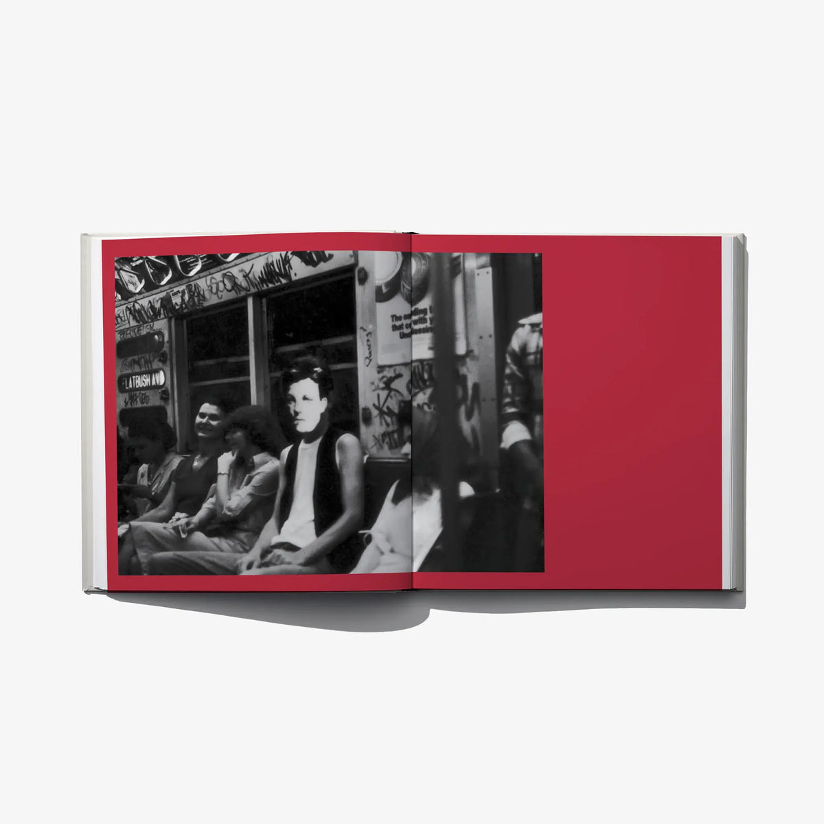 Open photo book spread with two black-and-white street photos on red page