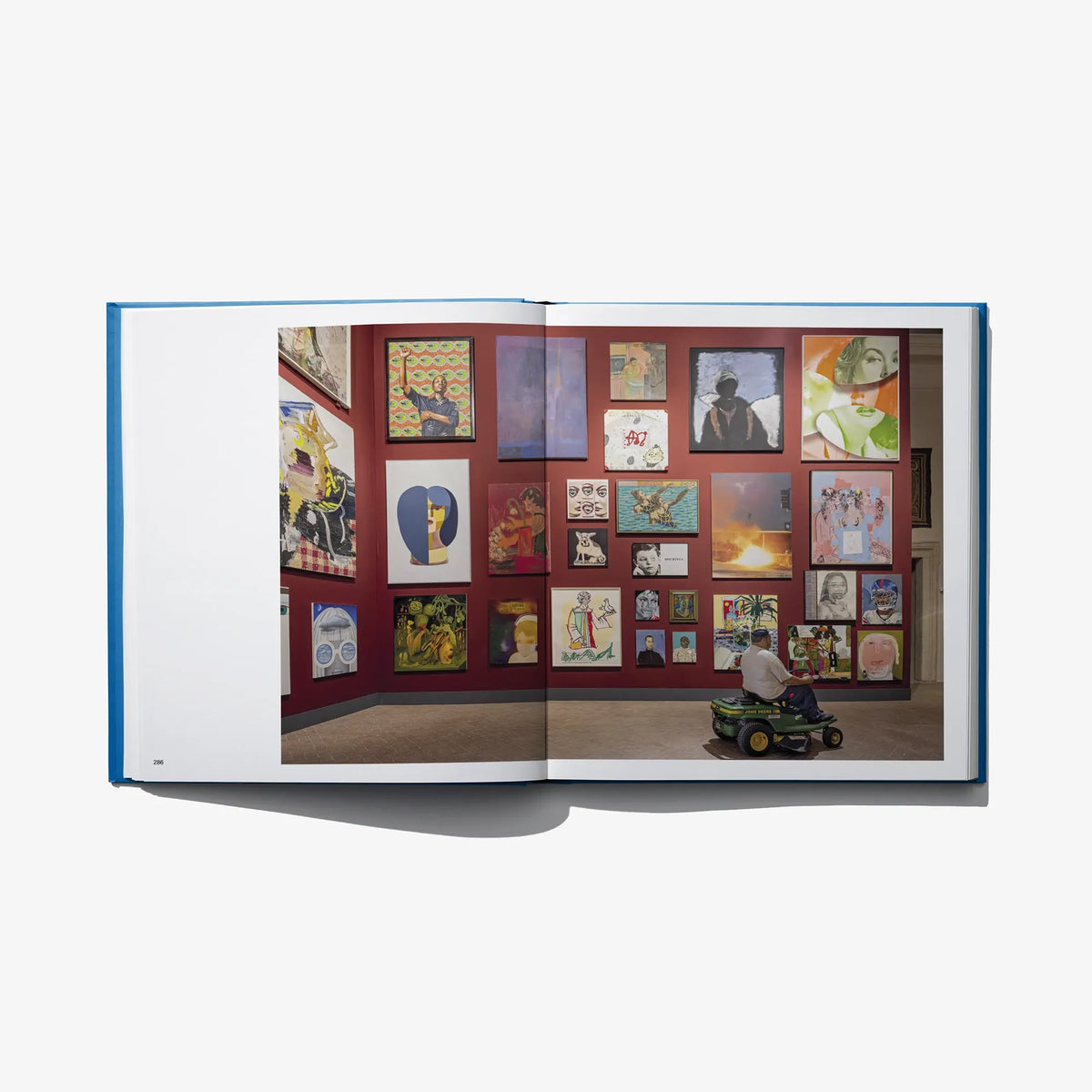 Open art book showing a wall of colorful framed artworks across both pages