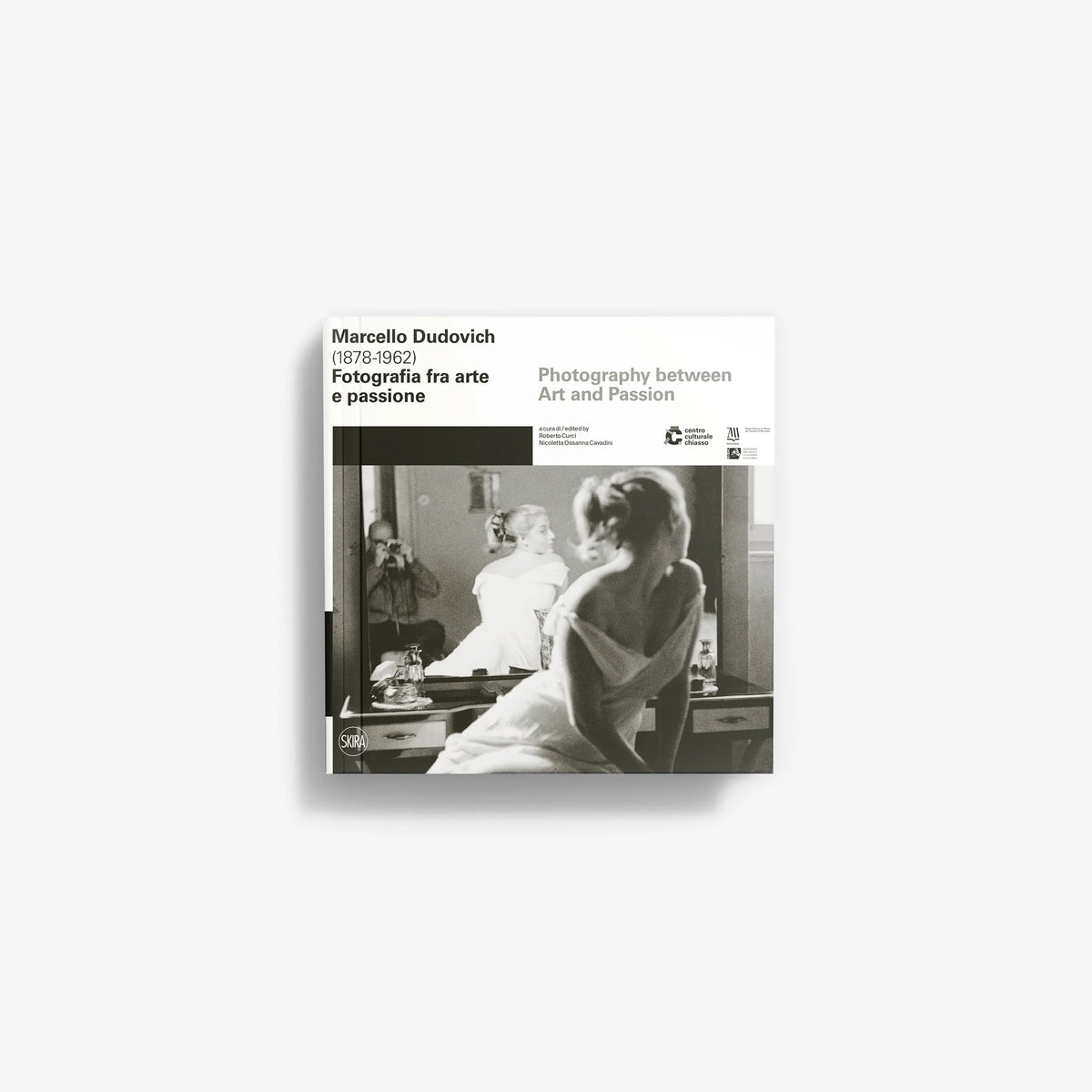 Black and white book cover featuring a vintage photograph of a woman sitting at a dressing table with a mirror and a lamp.