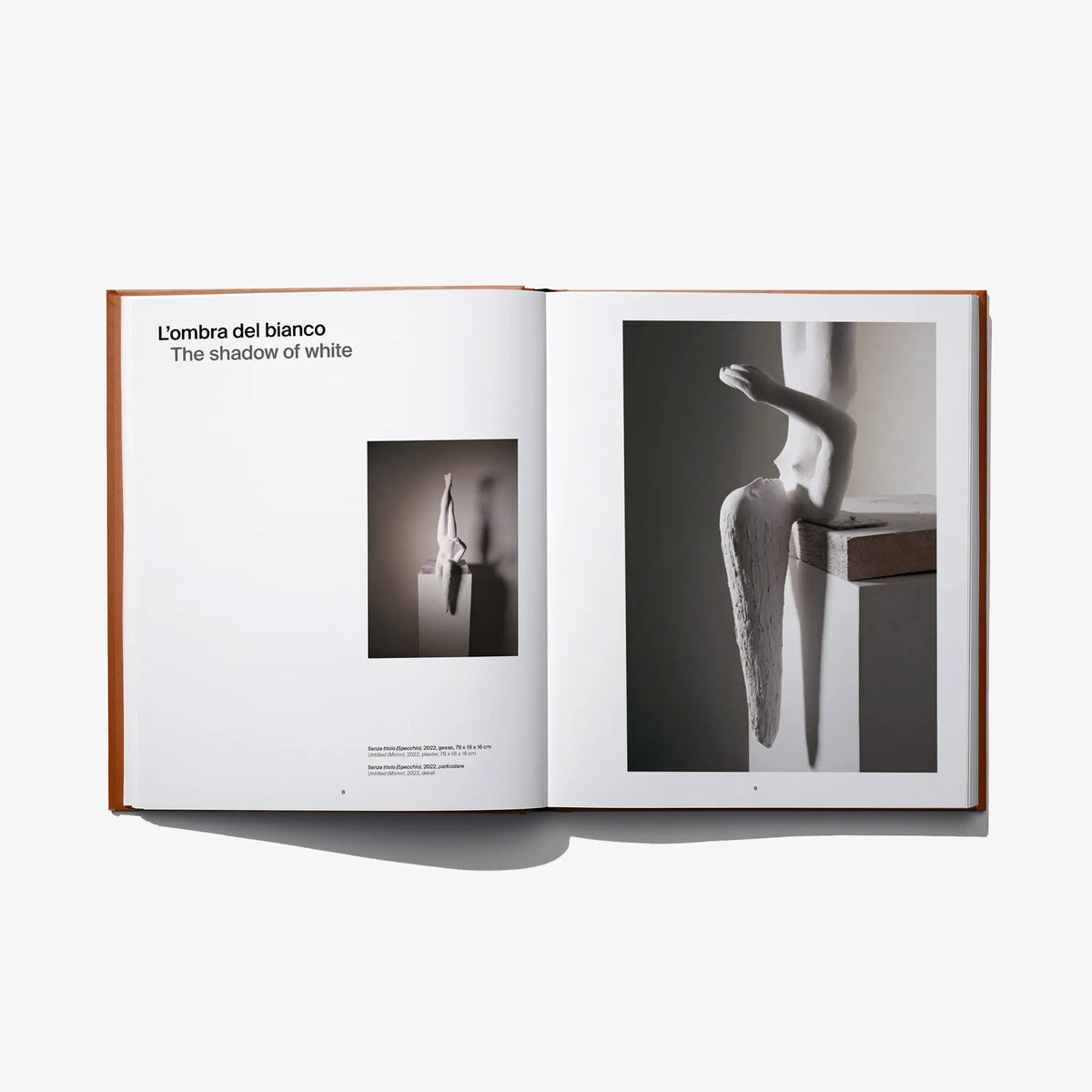 Open art book spread with black-and-white body photos and small thumbnail inset