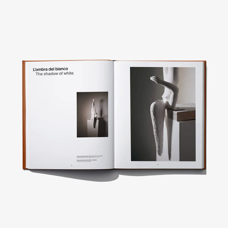 Open art book spread with black-and-white body photos and small thumbnail inset