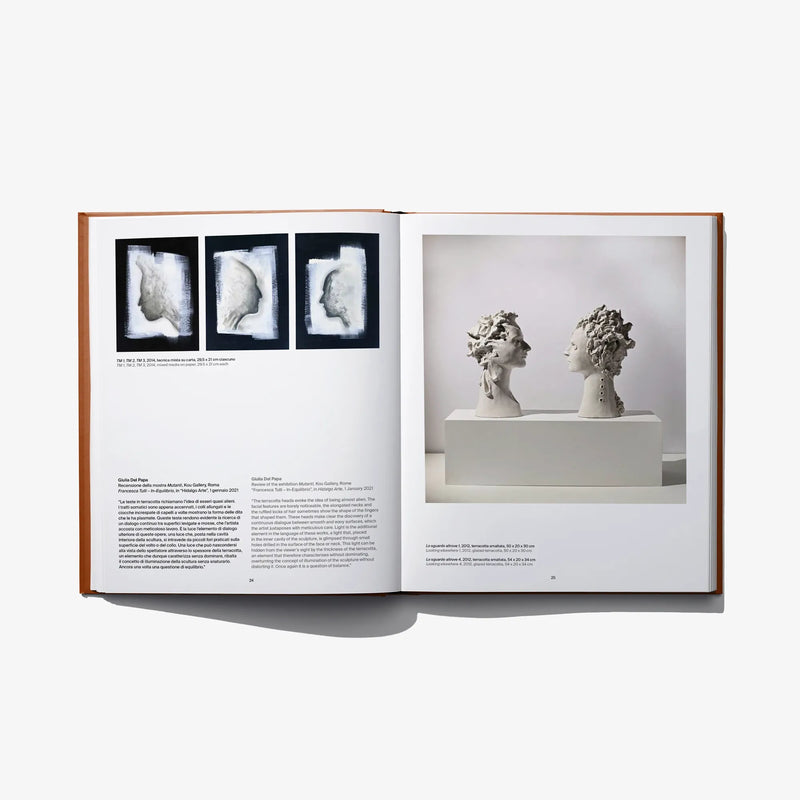 Open art book spread with monochrome sculpture photos on the right page