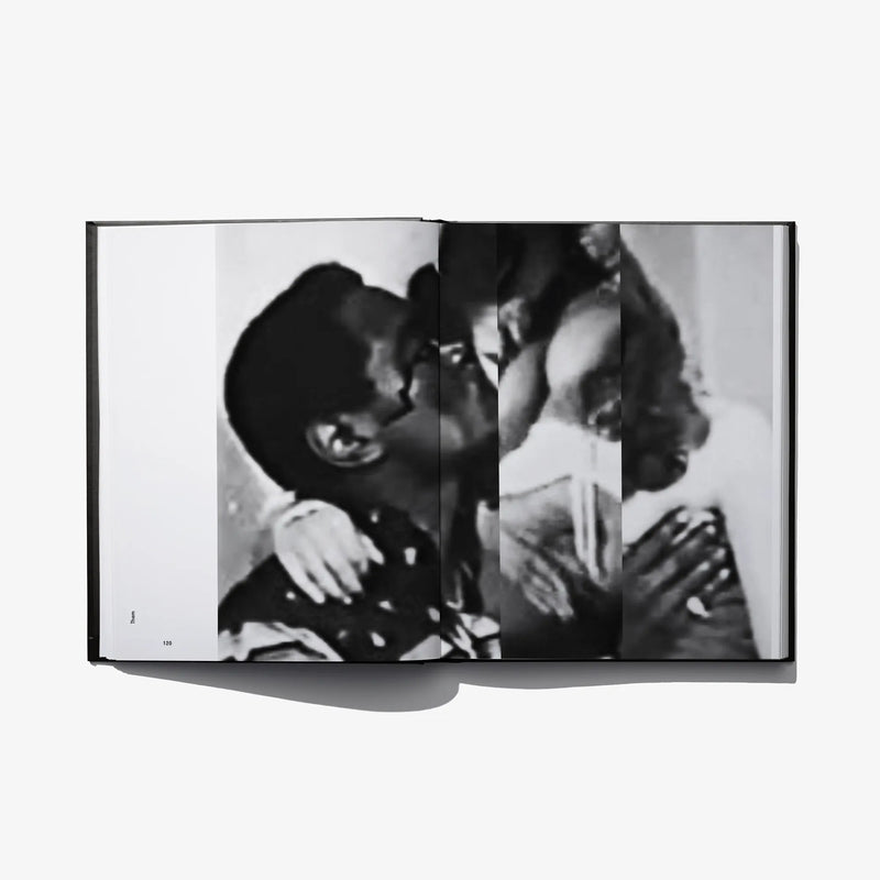 Open photo book spread with black-and-white couple embrace in dark clothing
