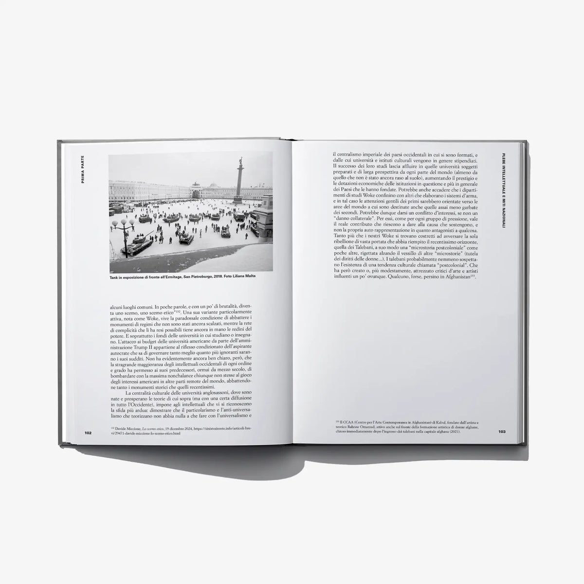 Open hardcover art book with photo of a city scene and printed paragraphs
