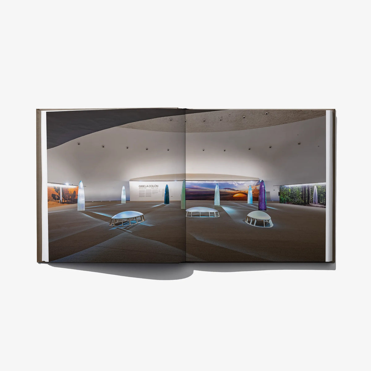 Open hardcover art book with modern interior photos and benches shown across pages