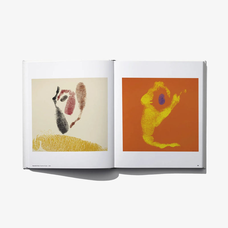 Open art book spread with two square prints on beige and orange backgrounds