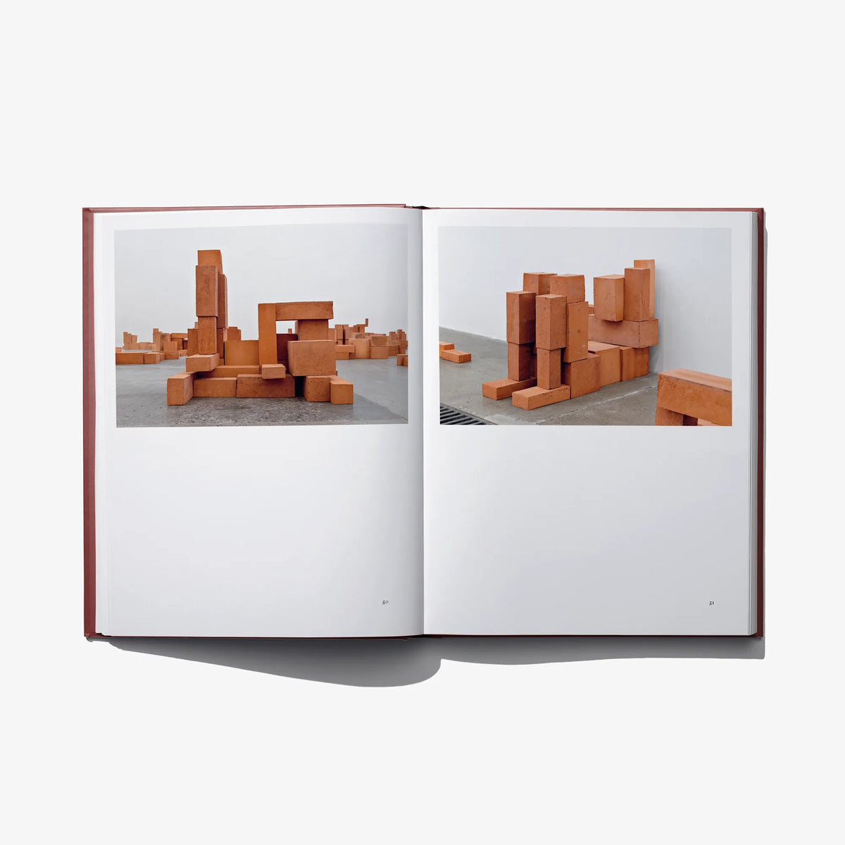 Open book spread featuring orange-brown block sculptures in two large photos.