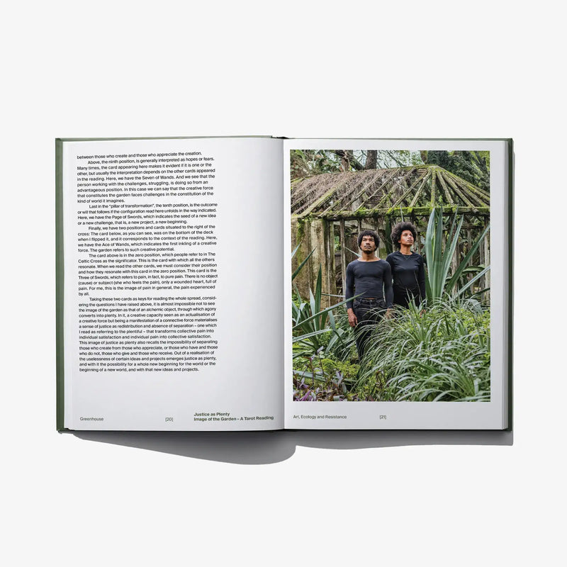 Opened hardcover book with text pages and a photo of two people among lush plants