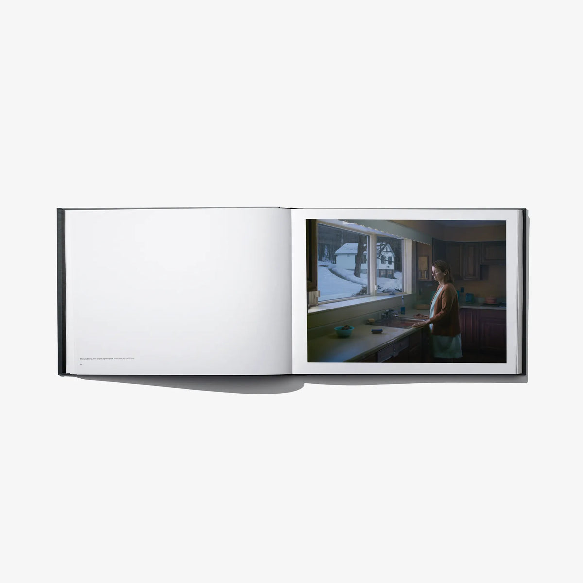 Open photo book spread with blank left page and kitchen interior photo on right