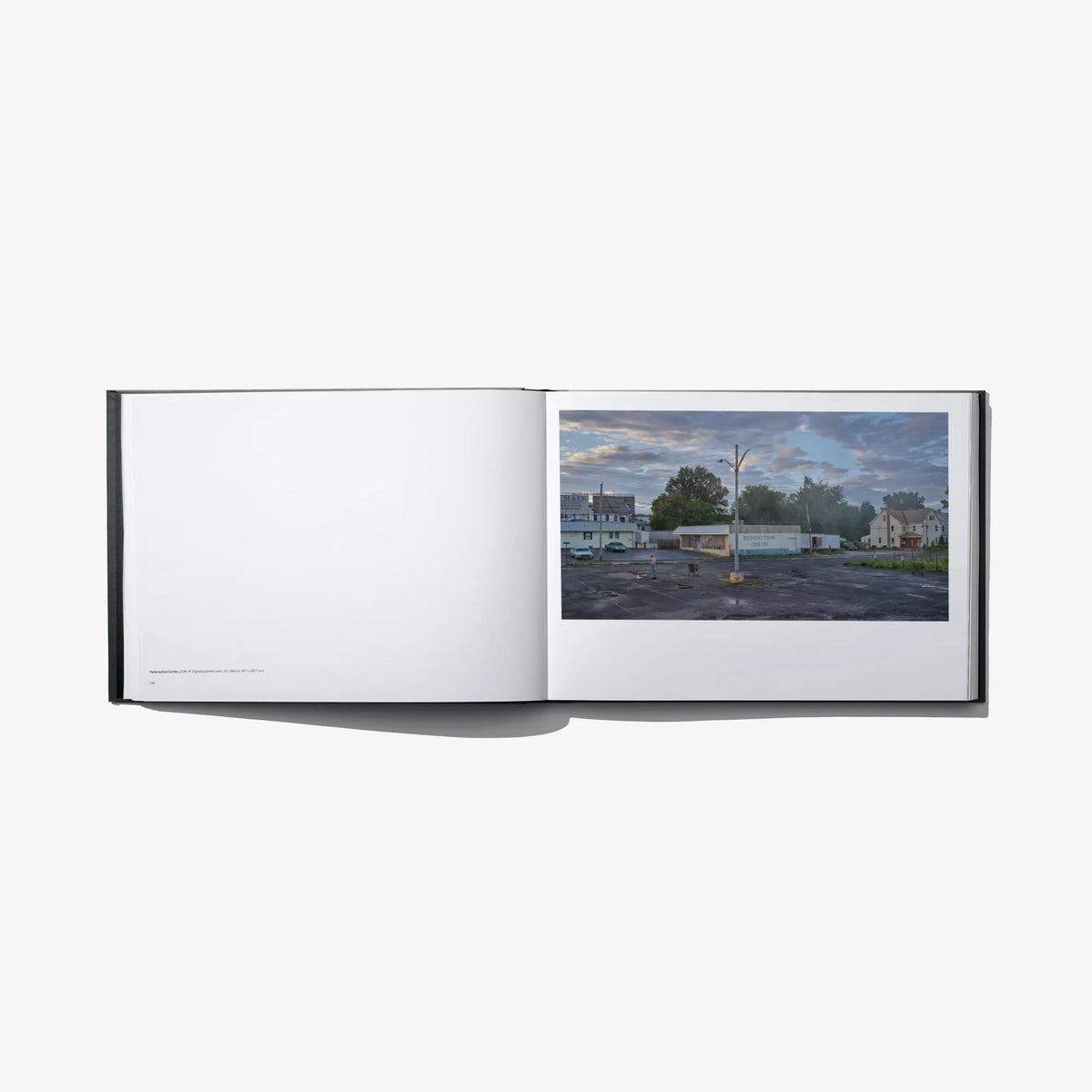 Open photo book spread with blank left page and street corner photo panel