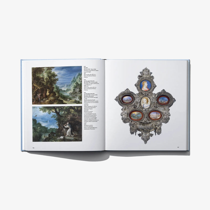 Open book spread with landscape prints and an ornate crest with blue medallions