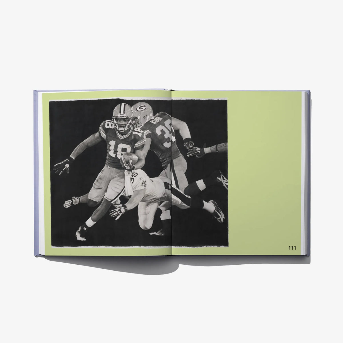Open art book spread with black-and-white football player photo on green background