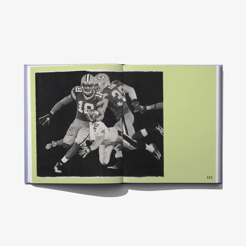 Open art book spread with black-and-white football player photo on green background