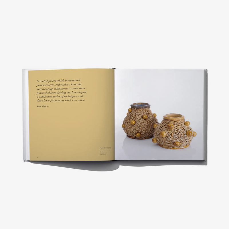 Open art book spread with ceramic vases and illustrated page text