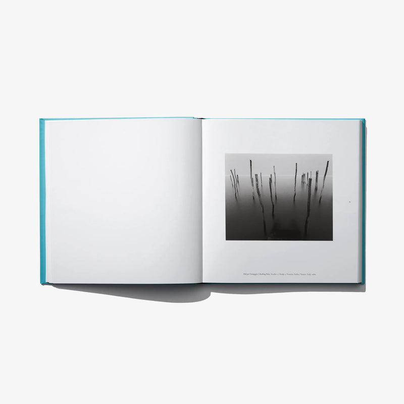 Open photo book with black-and-white abstract print on right page.