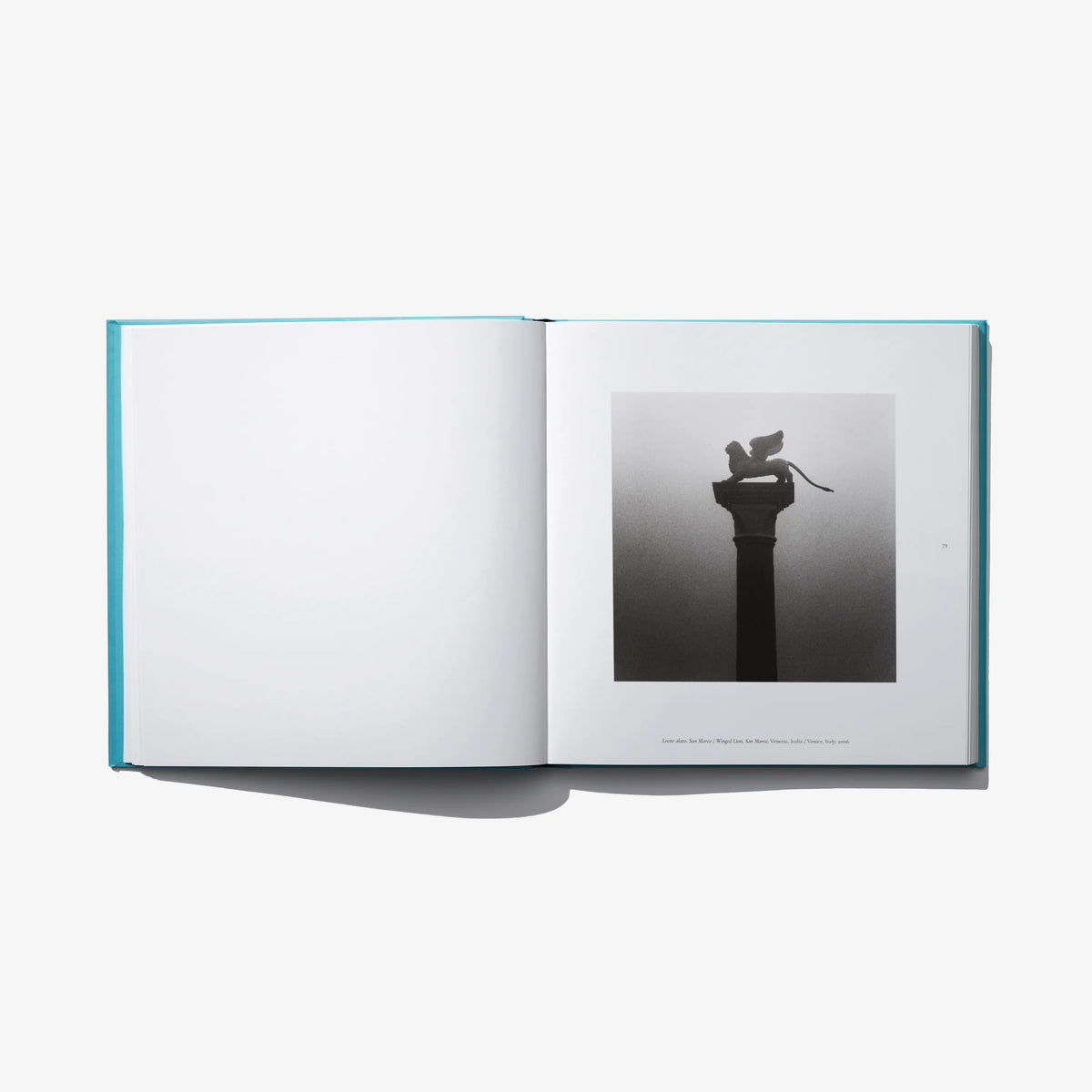 Open photo book spread with black-and-white monument photo on right page.
